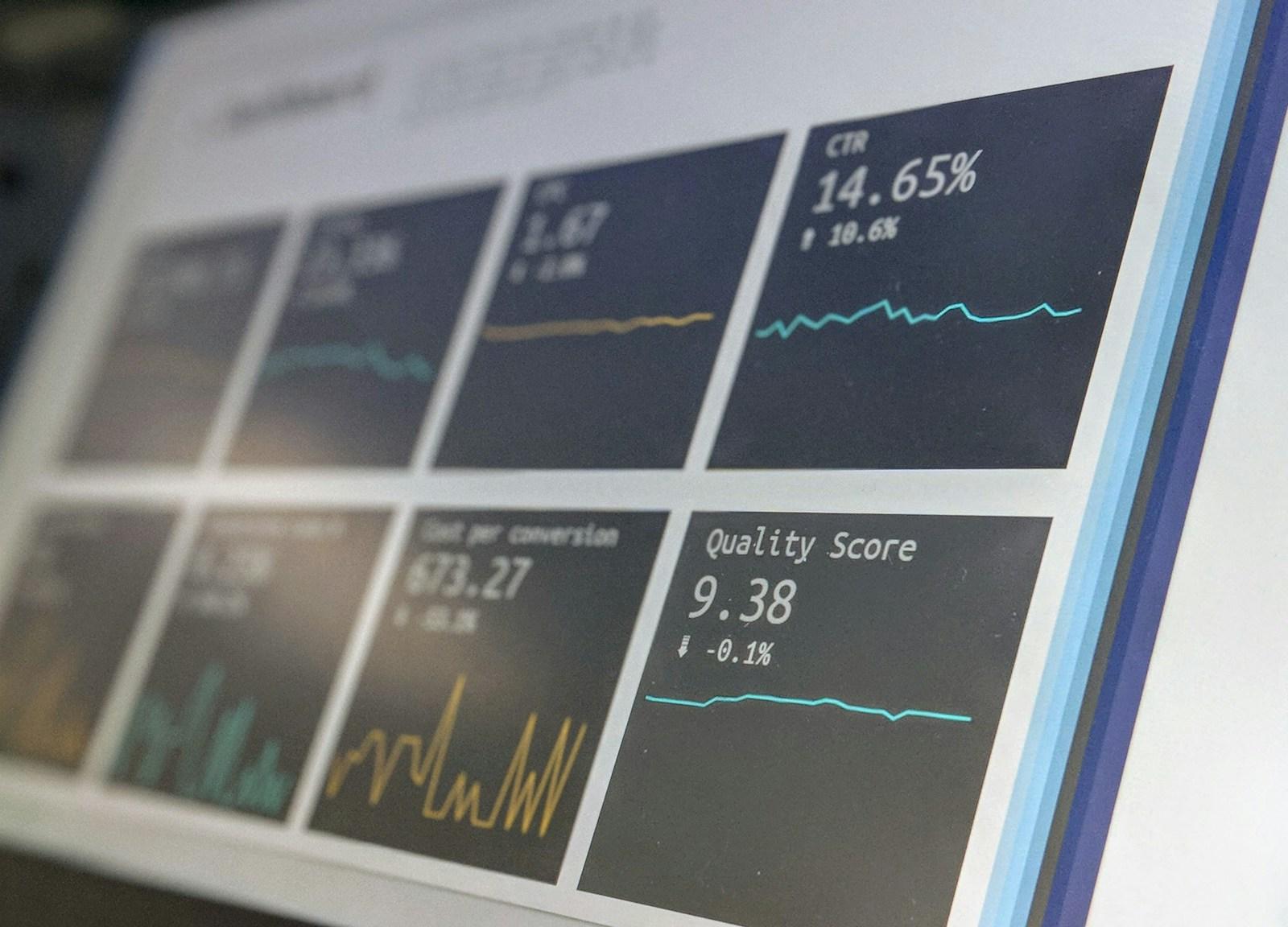 A monitoring dashboard on a screen, showing live metric tiles and trend lines.